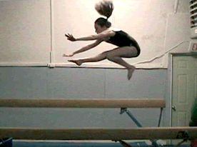 An Empire Student demonstrates a Wolf Jump on the Balance Beam